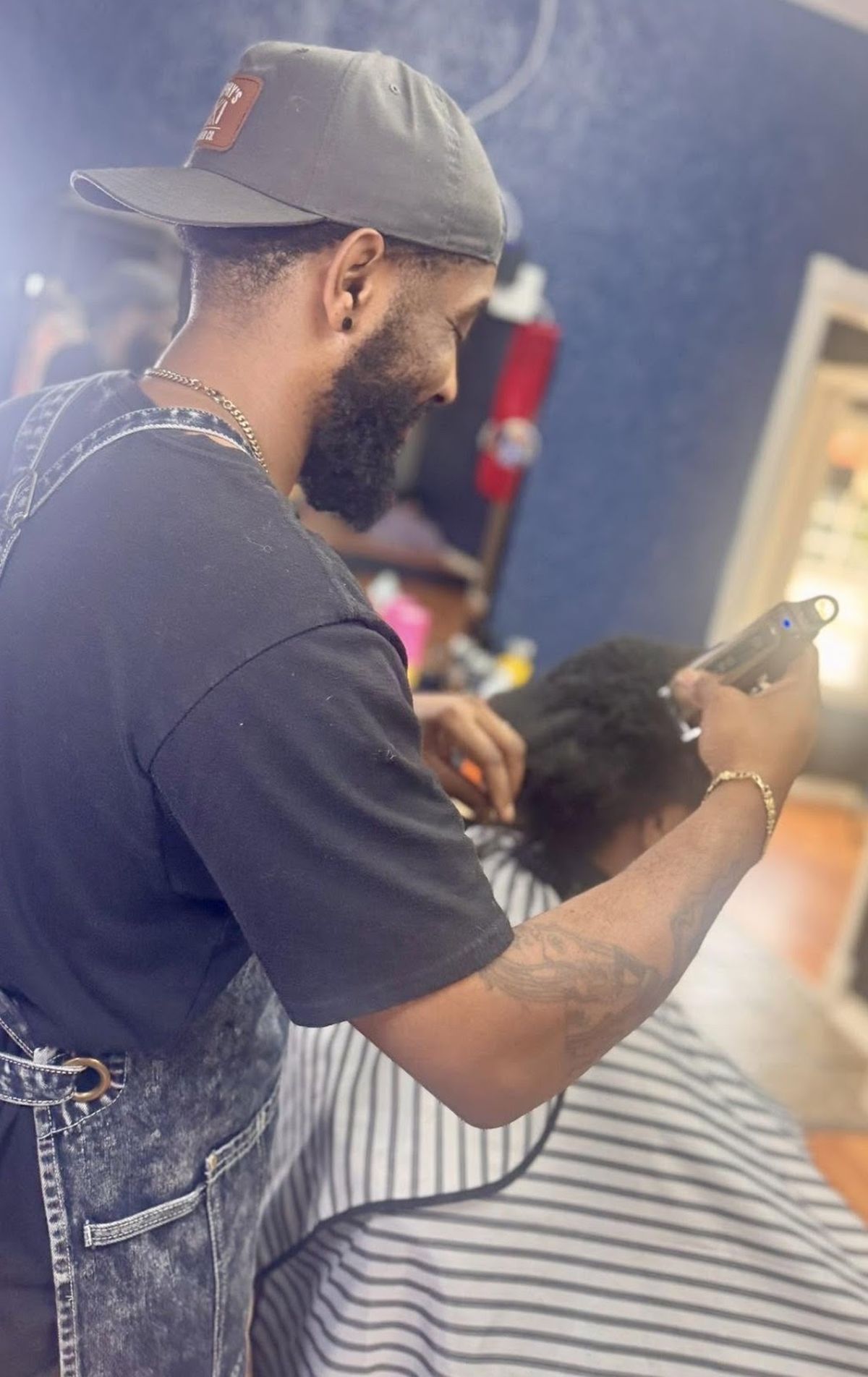 Adrian at Murphy's Barber Co lining up a client's fade with clippers